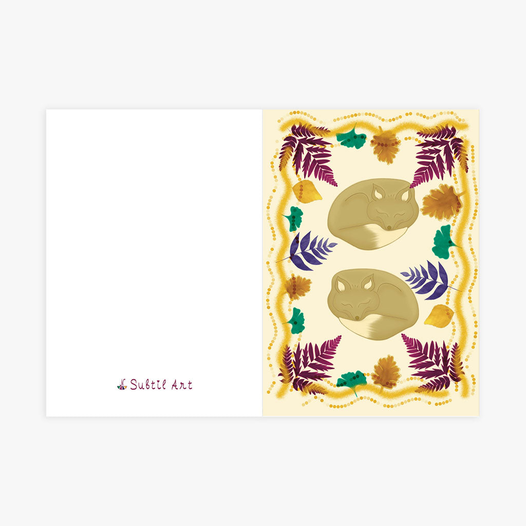 Greetings Card A5 Folded - Woodland design featuring sleeping foxes with autumn foliage in deep jewel tones and golden accents, bordered by decorative dotted frame
